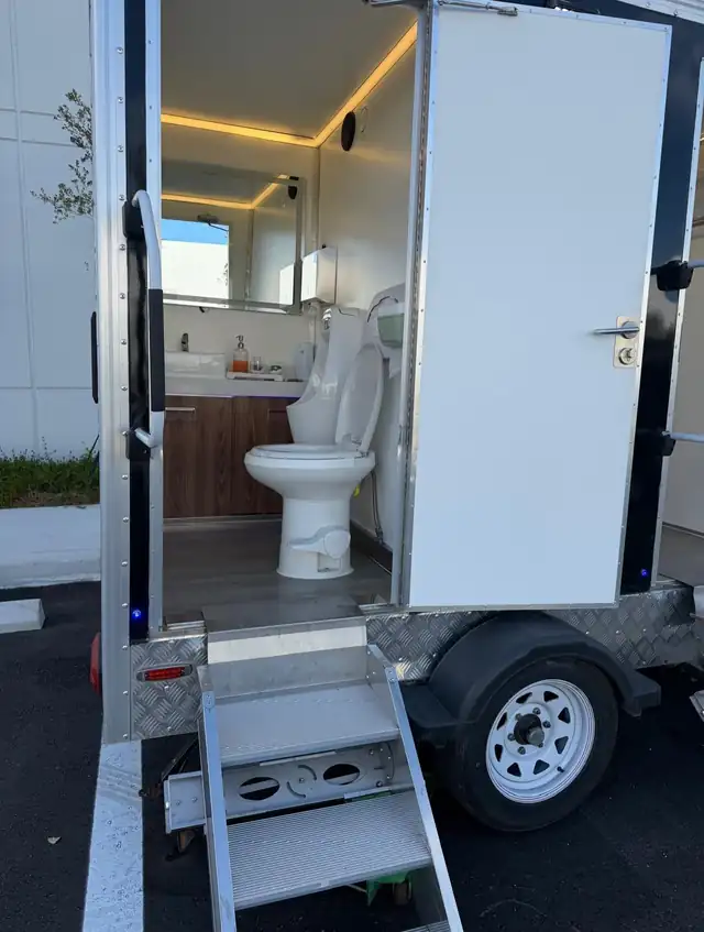 Restroom trailer stall with vanity and lighting